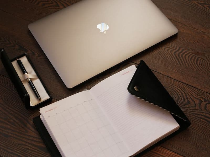 silver macbook on brown table